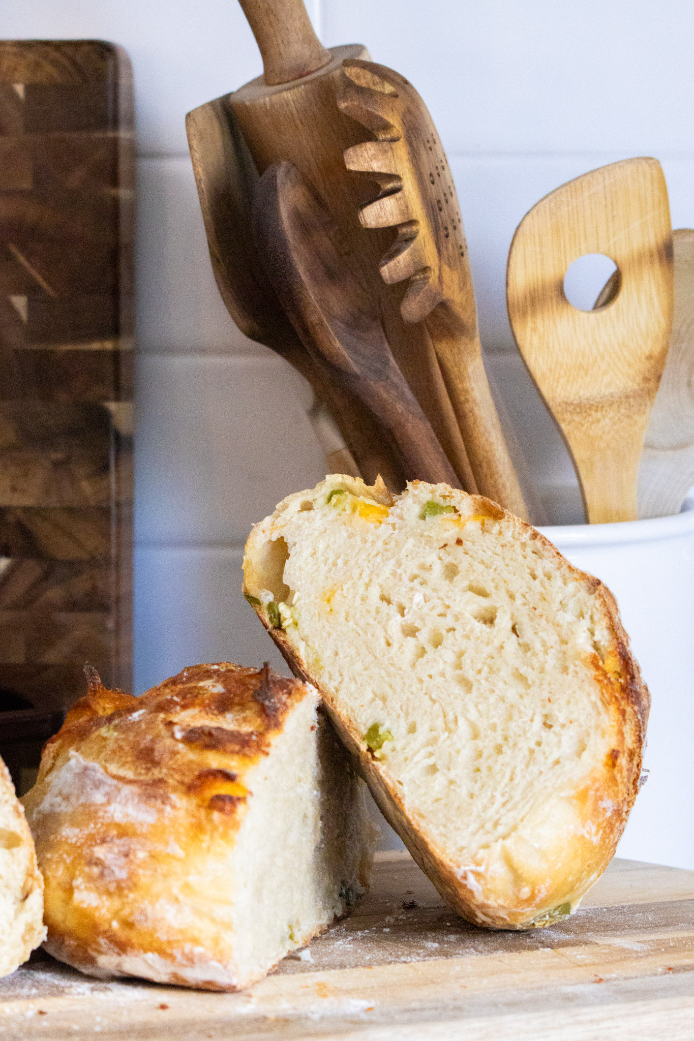 A whole country loaf, just out of the oven, on a wooden board